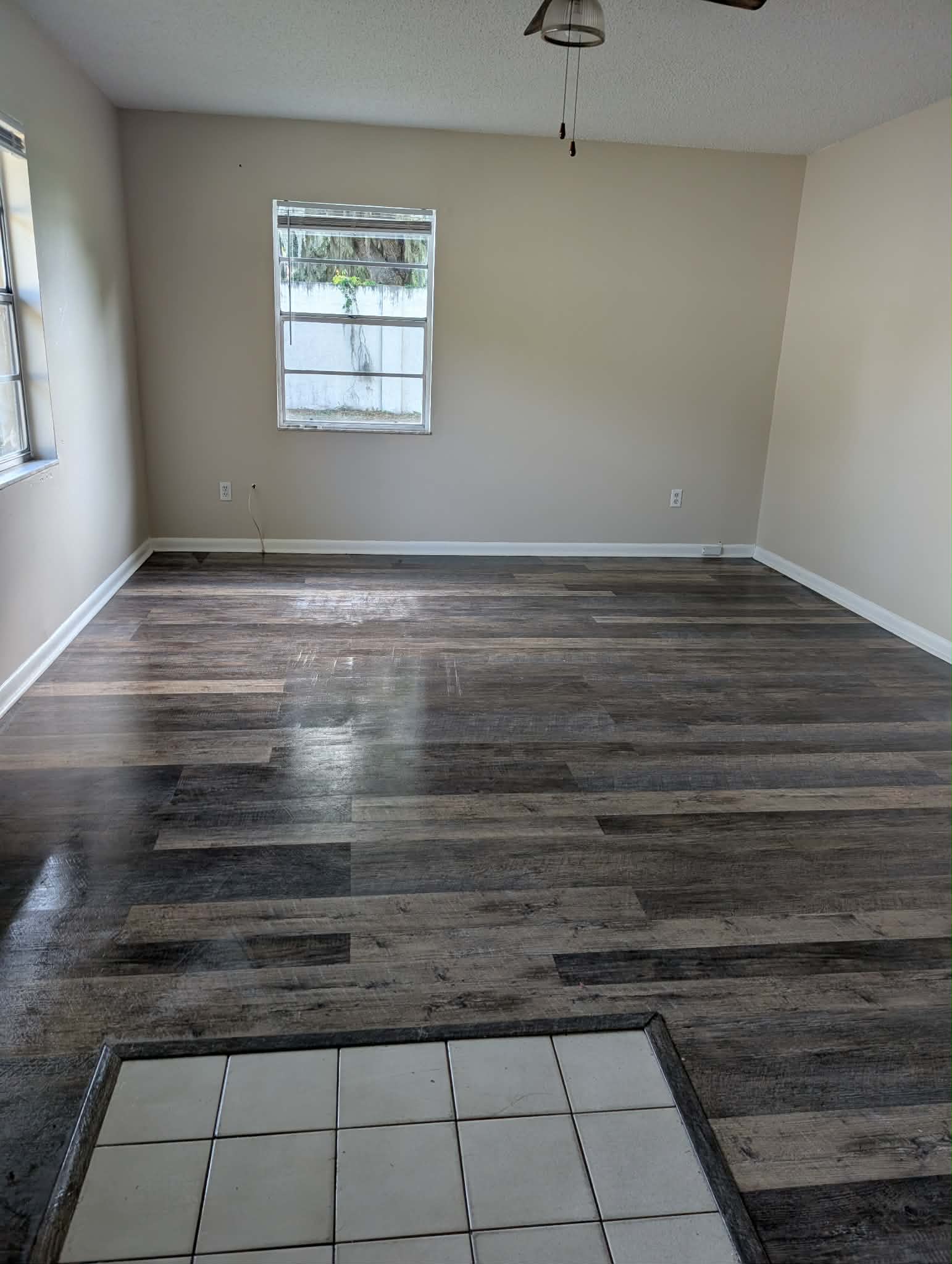 Real job — clean living room window with bright glossy floors after a Squeaky Clean visit